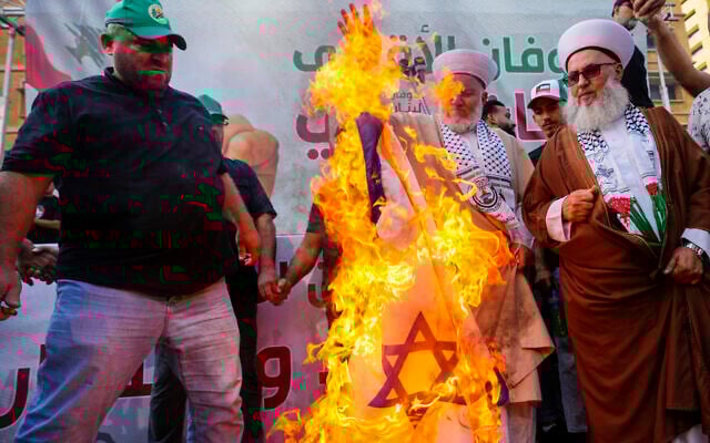 Members of Hezbollah and Hamas supporters burn an Israeli flag during a rally in Beirut, Lebanon, October 29, 2023. (AP Photo/Hassan Ammar) Members of Hezbollah and Hamas supporters burn an Israeli flag during a rally in Beirut, Lebanon, October 29, 2023. (AP Photo/Hassan Ammar)