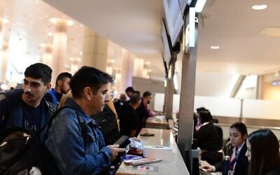 Illustrative: People check in at a counter at Ben Gurion International Airport in November 2022. (Tomer Neuberg/Flash90)