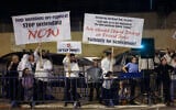 Dozens of Orthodox Jews hold signs during a protest outside a Christian Embassy Feast of Tabernacles eventa t the Pais Arena stadium in Jerusalem on October 3, 2023. (Chaim Goldberg/Flash90)