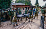Israeli soldiers remove bodies of Israeli civilians in Kibbutz Kfar Aza, near the Israeli-Gaza border, in southern Israel, October 10, 2023. (Chaim Goldberg/Flash90)