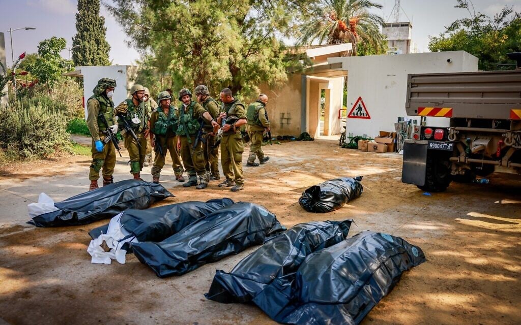 Israeli soldiers remove bodies of Israeli civilians killed by Hamas terrorists in Kibbutz Kfar Aza, near the Israeli-Gaza border, in southern Israel, October 10, 2023. (Chaim Goldberg/Flash90) Israeli soldiers remove bodies of Israeli civilians killed by Hamas terrorists in Kibbutz Kfar Aza, near the Israeli-Gaza border, in southern Israel, October 10, 2023. (Chaim Goldberg/Flash90)