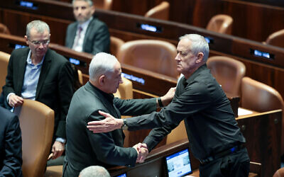 File - Prime Minister Benjamin Netanyahu shakes the hand of then-newly appointed minister Benny Gantz at a special session presenting the new emergency government at the Knesset plenum in Jerusalem, October 12, 2023. (Noam Revkin Fenton/Flash90)