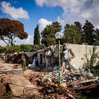 Israeli soldiers survey the destruction caused by Hamas terrorists in Kibbutz Kfar Aza, near the Israel-Gaza border, in southern Israel, October 15, 2023. (Chaim Goldberg/ Flash90)