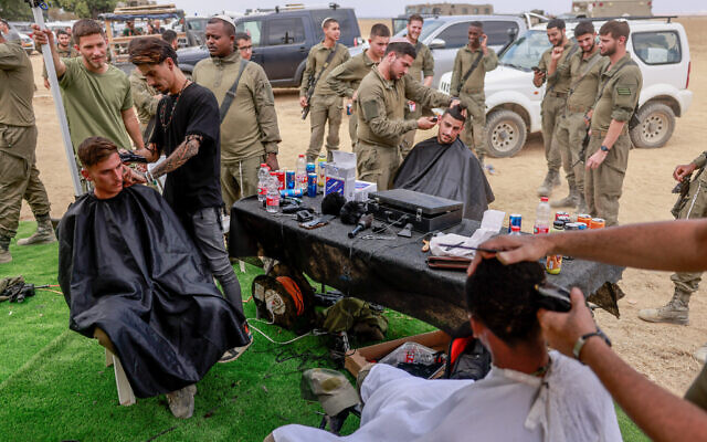 Israeli volunteers offer haircuts to Israeli soldiers based near the southern Israeli border with Gaza, October 16, 2023. (Chaim Goldberg/Flash90) Israeli volunteers offer haircuts to Israeli soldiers based near the southern Israeli border with Gaza, October 16, 2023. (Chaim Goldberg/Flash90)