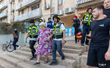 Police evacuate a woman in Sderot from a building hit by a rocket fired from the Gaza Strip by Palestinian terrorists on October 17, 2023. (Yossi Aloni/Flash90)