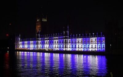 The Palace of Westminster, the home of the UK Houses of Parliament in London, is lit up in the colors of Israel’s flag for victims and hostages of Hamas attacks, Oct. 9, 2023. (Lucy North/PA Images via Getty Images, via JTA)