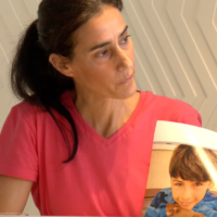 Bat-Sheva Yahalomi, holding a photo of her 12-year-old son, Eitan, who she believes was taken captive into Gaza on October 7, 2023 (Courtesy)