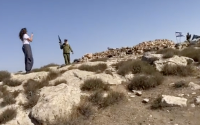 An armed Israeli man fires an assault rifle the air during a confrontation with unarmed anti-occupation activists, October 25, 2023 (Screenshot; used in accordance with Clause 27a of the Copyright Law)