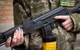 FILE - A Ukrainian civil defense member holds a Kalashnikov assault rifle while patrolling in Kyiv, Ukraine, February 27, 2022. (AP Photo/Efrem Lukatsky, File)