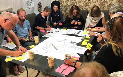 Participants complete an exercise during a dialogue session at a sukkah as part of the SOS Home project, October 2023. (Courtesy/SOS Home via JTA)