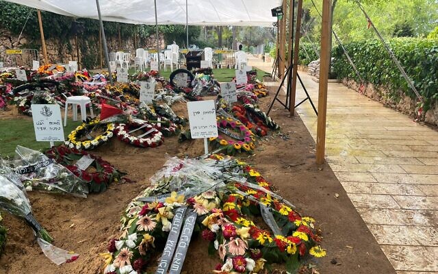 Wreaths cover recently dug graves of fallen soldiers in the Mount Herzl Military Cemetery in Jerusalem, October 15, 2023. (Shira Silkoff)