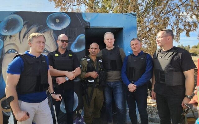 Outside of bunker in which Re'im musical festival attendees were murdered by Hamas stand: Latvian MP Rihards Kols, Knesset Speaker MK Amir Ohana, IDF Col (Res) Golan Vach, Estonian MP Marko Mihkelson, MK Yuli Edelstein, Lithuanian MP Žygimantas Pavilionis, October 17, 2023. (Courtesy: MK Yuli Edelstein) Outside of bunker in which Re'im musical festival attendees were murdered by Hamas stand: Latvian MP Rihards Kols, Knesset Speaker MK Amir Ohana, IDF Col (Res) Golan Vach, Estonian MP Marko Mihkelson, MK Yuli Edelstein, Lithuanian MP Žygimantas Pavilionis, October 17, 2023. (Courtesy: MK Yuli Edelstein)