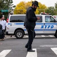Illustrative: A man walks as police patrol a neighborhood in Brooklyn with a large Orthodox Jewish community on October 12, 2023, in New York City. (Spencer Platt/ Getty Images/AFP)