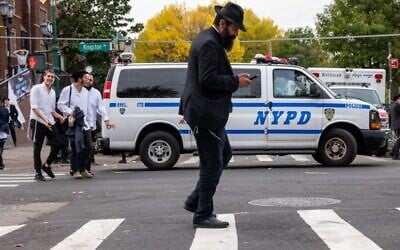 Illustrative: A man walks as police patrol a neighborhood in Brooklyn with a large Orthodox Jewish community on October 12, 2023, in New York City. (Spencer Platt/ Getty Images/AFP)