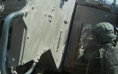 A Border Police officer about to open the door of a tank and rescue wounded IDF soldiers who had taken shelter inside on October 7, 2023, from a video released by the Israel Police on October 10, 2023. (Israel Police)