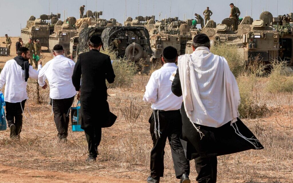 Illustrative: Haredi Jews visit Israeli soldiers to show their support as they deploy at a position near the border with Gaza in southern Israel on October 11, 2023. (Menahem Kahana/AFP)