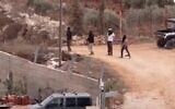 An image that appears to show masked settlers near the West Bank village of Qusra, October 11, 2023. (Screenshot, X used in accordance with Clause 27a of the Copyright Law)