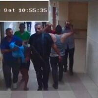 Hamas terrorists bring a hostage into Shifa Hospital as seen on surveillance footage from October 7, 2023. (IDF)