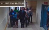 Hamas terrorists bring a hostage into Shifa Hospital, as seen on surveillance footage from October 7, 2023. (IDF)