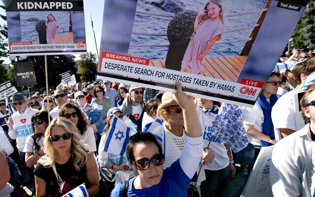 People hold a poster bearing a photo of Israeli hostage Yoni Asher during a rally in support of Israel outside the Colorado State Capitol Building in Denver, Colorado, on October 15, 2023. (Jason Connolly / AFP)