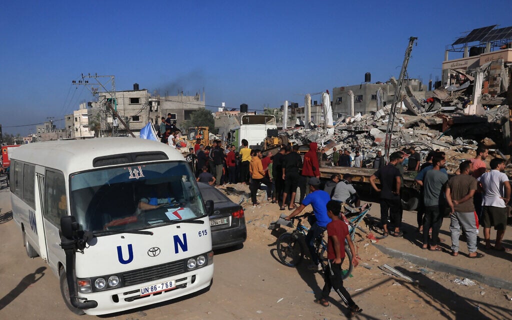 A UN bus drives past a destroyed building in Rafah in the southern Gaza Strip on November 10, 2023 (Photo by SAID KHATIB / AFP)