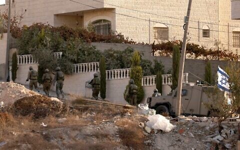 Illustrative: Israeli troops are seen in the West Bank city of Hebron on November 10, 2023. (HAZEM BADER / AFP)