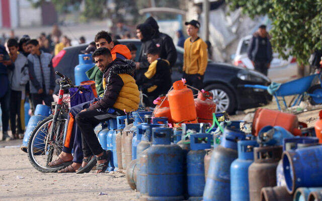 People sit with empty canisters waiting for them to be filled with cooking gas from a tank that entered the Palestinian enclave via the Rafah crossing with Egypt, in Rafah in the southern Gaza Strip on November 25, 2023 (SAID KHATIB / AFP) People sit with empty canisters waiting for them to be filled with cooking gas from a tank that entered the Palestinian enclave via the Rafah crossing with Egypt, in Rafah in the southern Gaza Strip on November 25, 2023 (SAID KHATIB / AFP)