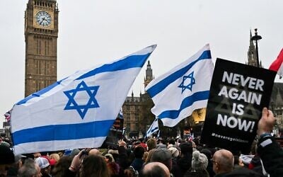 Illustrative: Protesters wave Israeli flags and hold placards at a rally against antisemitism in front of Big Ben at the UK Houses of Parliament in central London, November 26, 2023. (Justin Tallis / AFP)