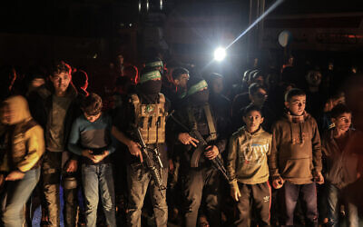 Children stand alongside Hamas terrorists in Khan Younis in the southern Gaza Strip on November 29, 2023. (AFP)