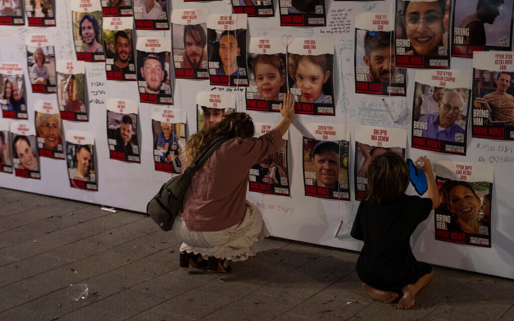An woman touches photos of Israelis missing and held captive in Gaza, displayed on a wall in Tel Aviv, on Oct. 21, 2023 (AP Photo/Petros Giannakouris) An woman touches photos of Israelis missing and held captive in Gaza, displayed on a wall in Tel Aviv, on Oct. 21, 2023 (AP Photo/Petros Giannakouris)