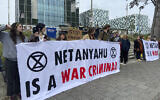 File - Activists hold up a banner denouncing Prime Minister Benjamin Netanyahu for Israel’s actions during the war with Hamas as they demonstrate at the entrance of the International Criminal Court in The Hague, Netherlands, October 23, 2023.  (Aleks Furtula/AP)
