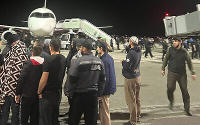 People in the crowd walk shouting antisemitic slogans at an airfield of the airport in Makhachkala, Russia, October 30, 2023. (AP Photo)