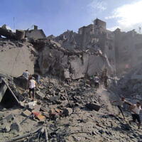 Palestinians inspect the damage of buildings destroyed after Israeli airstrikes on the Jabaliya refugee camp on the outskirts of Gaza City, October 31, 2023. The IDF said the airstrikes were part of 'a wide-scale strike' on Hamas operatives and infrastructure belonging to the terror group’s Central Jabaliya Battalion and that the buildings collapsed when Hamas tunnels were targeted. (Abdul Qader Sabbah/AP)