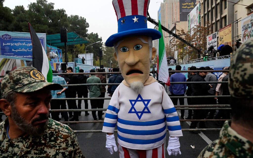 An Iranian man wears Uncle Sam costume with Israeli flag during a rally in front of the former US Embassy in Tehran, Iran, Nov. 4, 2023. (AP Photo/Vahid Salemi)