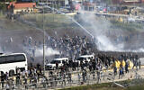 People clash with Turkish anti-riot police officers during a protest to show solidarity with the Palestinians outside the US - Turkish Incirlik military air base in Adana, southern Turkey, November 5, 2023. (Mehmet Sancakzade/AP)