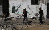 Palestinians walk through a destroyed street after an Israeli raid in Tulkarem in the West Bank on Tuesday, November 7, 2023. (AP/Majdi Mohammed)