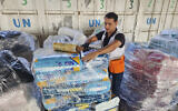 File: United Nations and Red Crescent workers prepare the aid for distribution to Palestinians at UNRWA warehouse in Deir Al-Balah, Gaza Strip, October 23, 2023. (AP Photo/Hassan Eslaiah)