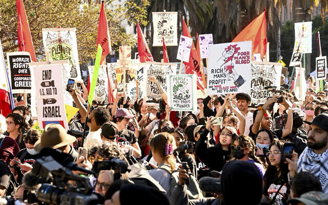 Demonstrators hold signs, including against US military aid to Israel, as they march in opposition to the APEC Summit, November 12, 2023, in San Francisco. (AP Photo/ Noah Berger)