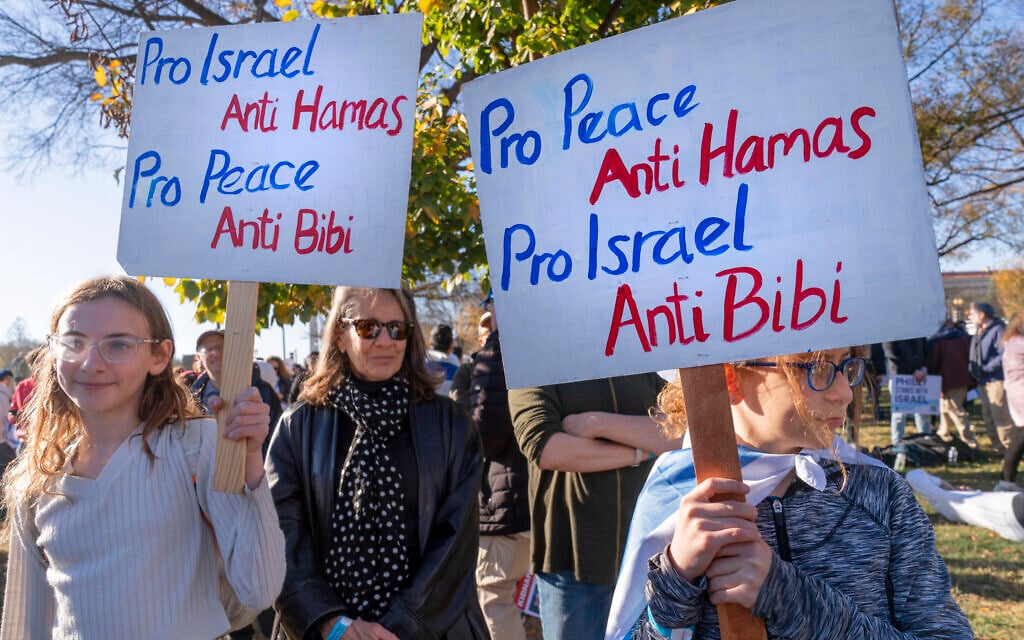 Noa Friedan, 13, left, and her sister Eila Friedan, 11, of Philadelphia, hold signs saying, 'Pro Israel, Anti Hamas; Pro Peace, Anti Bibi' as they attend the March for Israel rally, November 14, 2023, at the National Mall in Washington. (AP Photo/Jacquelyn Martin)
