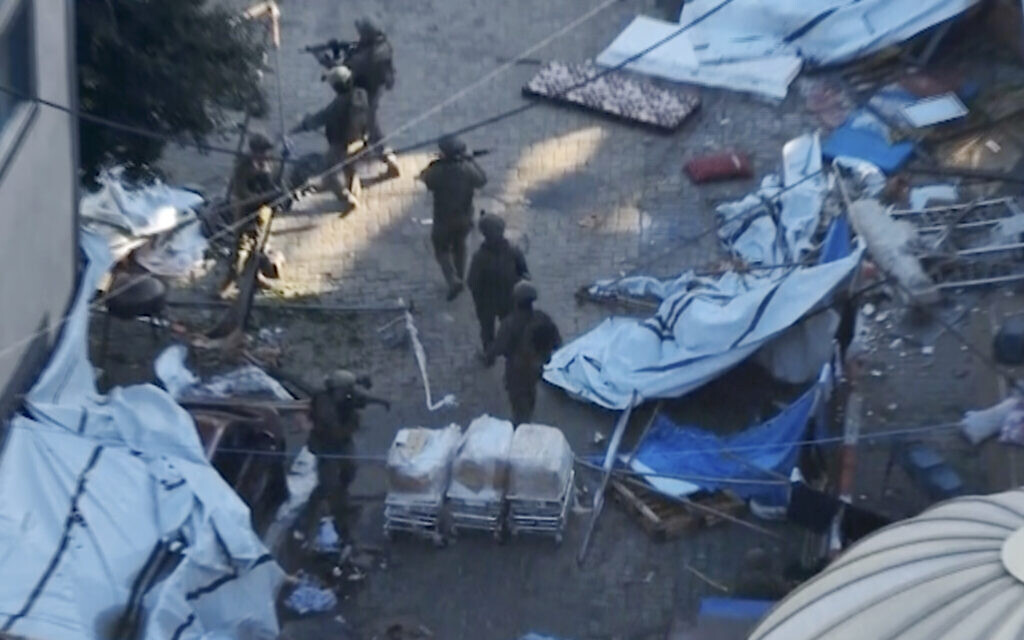 In this image taken from a video released by the IDF on November 15, 2023, Israeli soldiers walk in the area of Shifa Hospital in Gaza City. (IDF via AP)