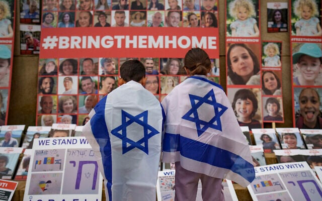 Children look at photographs of Israelis kidnapped by Hamas during a rally joined by hundreds in solidarity with Israel and those held hostage in Gaza, in Bucharest, Romania on Nov. 2, 2023. (AP Photo/Vadim Ghirda)