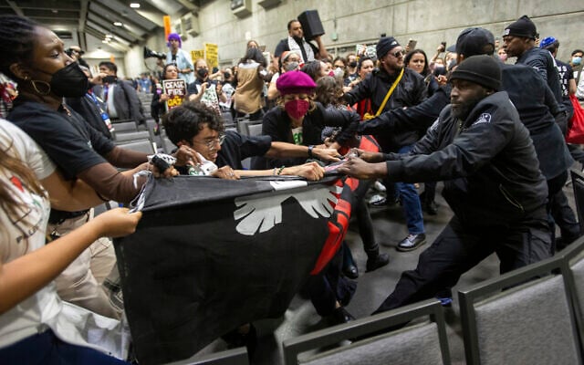 Pro-Palestinian demonstrators wrestle with security personnel as they carry a banner during a protest at SAFE Credit Union Convention Center, Saturday, Nov. 18, 2023, in Sacramento, Calif. (Paul Kitagaki Jr./The Sacramento Bee via AP)