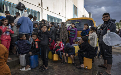 Palestinians queue for water at a UN displacement camp in the southern town of Khan Younis, Gaza Strip, Sunday, Nov. 19, 2023. (AP Photo/Fatima Shbair)