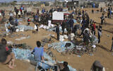 Palestinians sell water they have looted from the humanitarian aid trucks during the ongoing Israel-Hamas war in the Gaza Strip at the border with Egypt in Rafah on Monday, Nov. 20, 2023. (AP Photo/Hatem Ali)