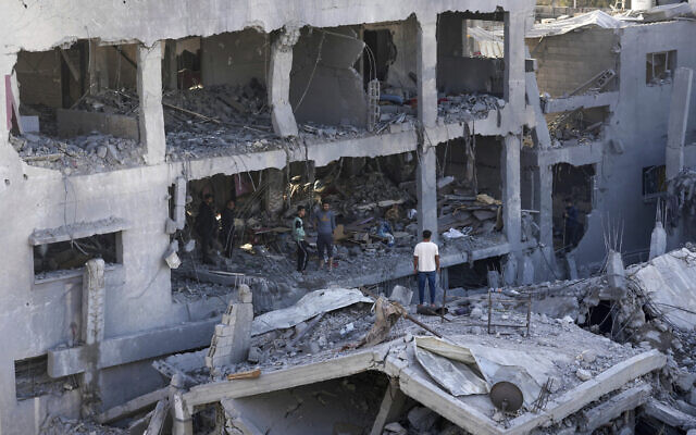 Palestinians inspect the rubble of destroyed building of the Muharib family in Nusseirat refugee camp, central Gaza on November 23, 2023. (AP Photo/Adel Hana) Palestinians inspect the rubble of destroyed building of the Muharib family in Nusseirat refugee camp, central Gaza on November 23, 2023. (AP Photo/Adel Hana)