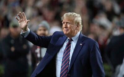 Republican presidential candidate and former US president Donald Trump waves during halftime of an NCAA college football game between South Carolina and Clemson, November 25, 2023, in Columbia, South Carolina. (Artie Walker Jr./AP) Republican presidential candidate and former US president Donald Trump waves during halftime of an NCAA college football game between South Carolina and Clemson, November 25, 2023, in Columbia, South Carolina. (Artie Walker Jr./AP)