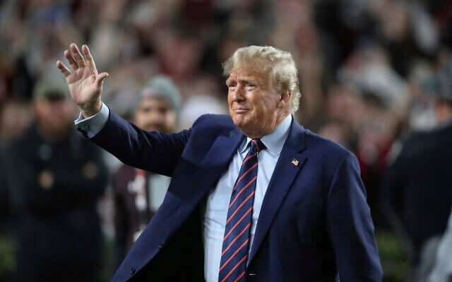 Republican presidential candidate and former US president Donald Trump waves during halftime of an NCAA college football game between South Carolina and Clemson, November 25, 2023, in Columbia, South Carolina. (Artie Walker Jr./AP) Republican presidential candidate and former US president Donald Trump waves during halftime of an NCAA college football game between South Carolina and Clemson, November 25, 2023, in Columbia, South Carolina. (Artie Walker Jr./AP)