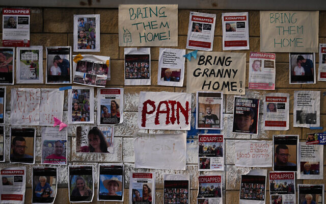 Photographs of people who were abducted during the devastating Hamas-led terror attack on southern Israel are fixed to a wall in Tel Aviv, October 27, 2023. (AP Photo/Francisco Seco, File)
