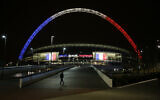 The arch of Wembley Stadium in London is seen lit up in the colors of the French flag above the words translated from French 'Liberty, Equality, Fraternity' as a mark of respect to the victims of the deadly attacks in Paris, November 16, 2015. (Matt Dunham/AP)