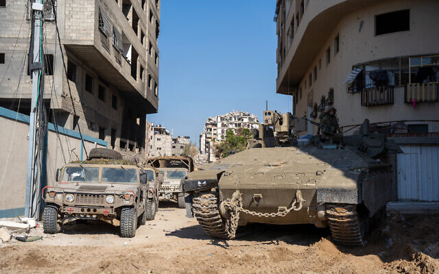 Damaged buildings and Israeli troops are seen in the northern Gaza Strip, November 16, 2023 (Emanuel Fabian/Times of Israel)